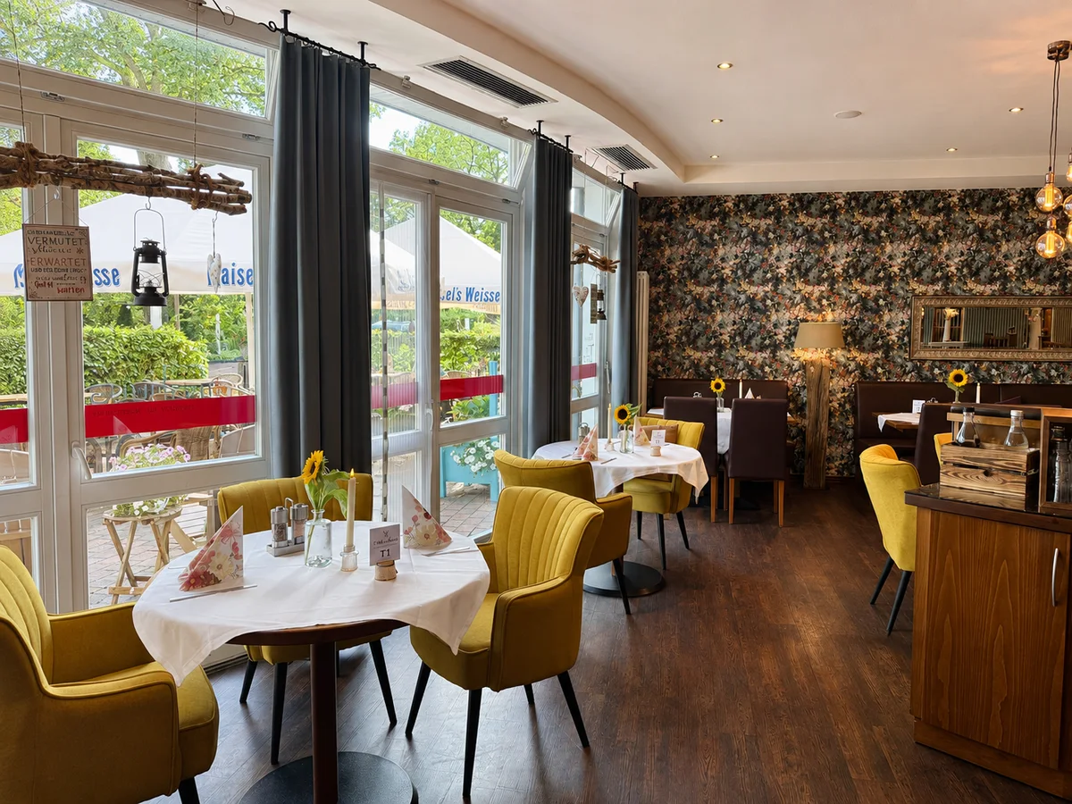 Heller Restaurantbereich mit eingedeckten Tischen